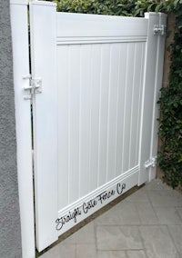 a white gate with a white sign on it