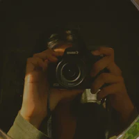 a person taking a picture with a camera in a mirror