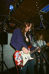 a man playing a guitar in front of a microphone