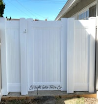 a white fence in a backyard with a white gate