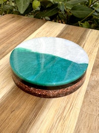 a green and white coaster on a wooden table