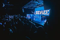 a crowd of people watching a dj at a nightclub