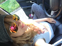 a woman sitting in the driver's seat of a car