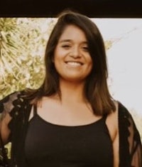 a woman in a black top smiling for the camera