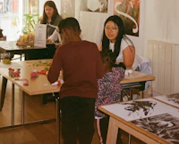 a group of people standing around a table with art on it