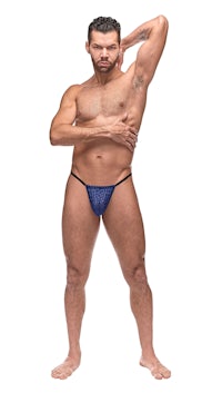 a man in a blue thong posing for a photo