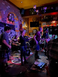 a group of people playing music in a bar