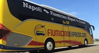 a yellow and yellow bus is parked in a parking lot