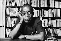 a man sitting at a desk with books in front of him