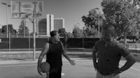 two men talking on a basketball court