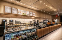 a starbucks coffee shop with a counter full of food