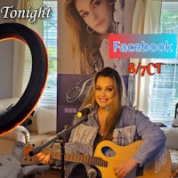 a woman is playing an acoustic guitar in a living room