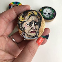 a person holding a piece of wood with a painting of a woman