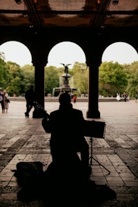 a man playing a guitar in a park