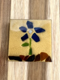 a blue glass flower on a wooden surface