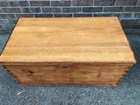 an old wooden trunk sitting on a brick wall
