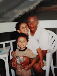 a man and two boys sitting on a chair
