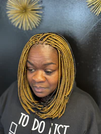 a woman wearing a black hoodie with yellow braids