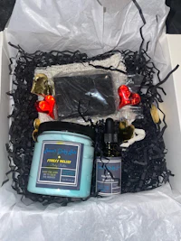 a gift box with a candle, soap, and other items