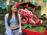 a woman standing in front of a flower garden