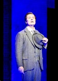 a man in a suit is holding a hat