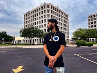 a man in a black shirt standing in front of a building