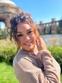 a woman smiling in front of a building in san francisco