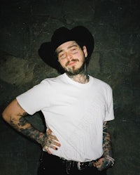 a man with tattoos and a cowboy hat