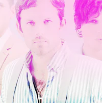 a group of men standing in front of a pink background