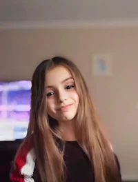a girl with long hair is smiling in front of a tv
