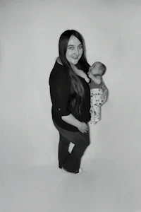 a black and white photo of a woman holding a baby