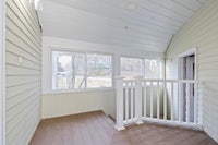 a porch with a wooden railing and a window