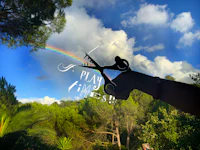 a person holding a pair of scissors in front of a rainbow