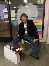 a man sitting on a bench with flowers