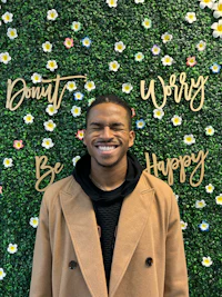 a man standing in front of a flower wall with the words worry don't be happy