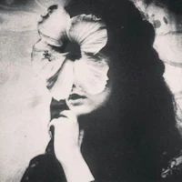 a black and white photo of a woman with a flower on her face