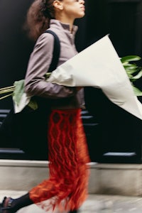 a woman carrying a bouquet of flowers