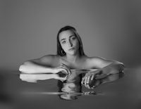 a black and white photo of a woman posing in water
