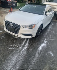 a white audi a4 parked on the side of the road