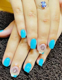 a woman's hand with blue nails and a ring on it