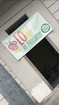 a sign that says love in progress on the side of a building