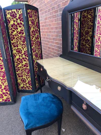 a dressing table with a mirror and a stool
