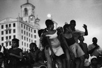 a black and white photo of a group of people in front of a building