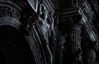 an ornate building with statues in the dark