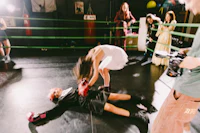 a woman laying on the ground in a boxing ring