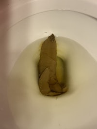 a toilet with a piece of paper in it