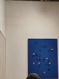a person is sitting at a table in an art gallery