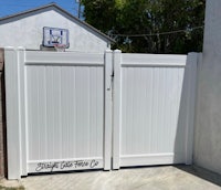 a white gate in front of a basketball court