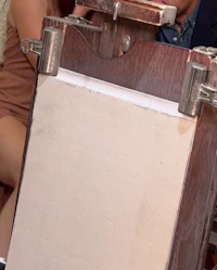 a woman is sitting in front of a painting easel