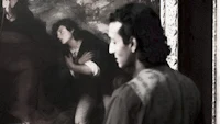 a man looking at a painting
